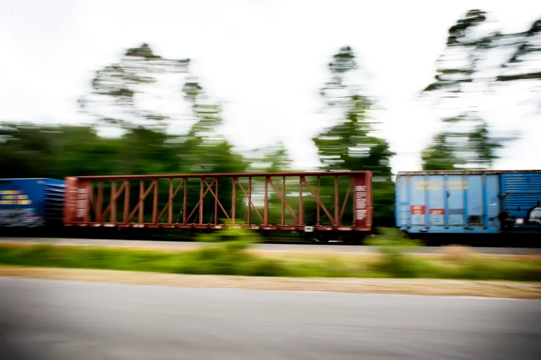 Modern train moving at high speed with long shadow